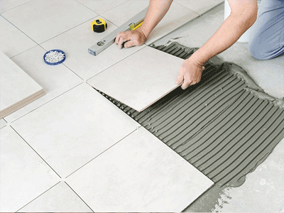 A person Installing Tiles on floor