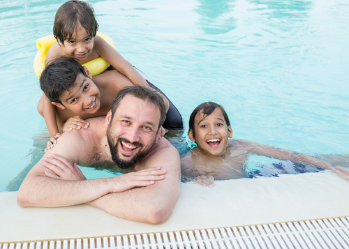 A man and children enjoying swimming pool